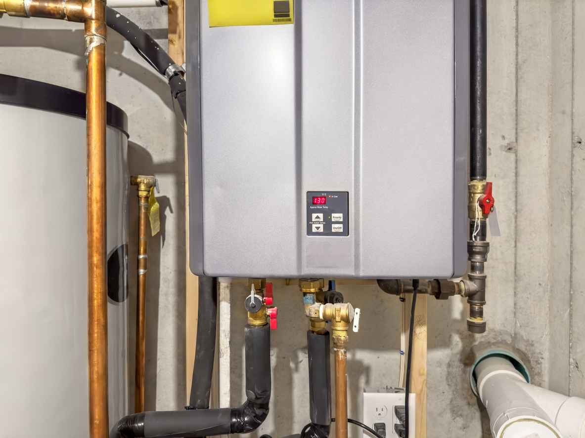 Tankless water heater unit mounted on basement wall